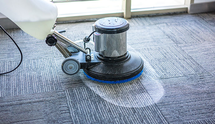 Professional rotary machine cleaning a commercial office carpet