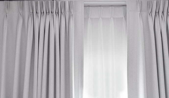 Luxury grey pinch-pleat curtains with white sheer under-curtains