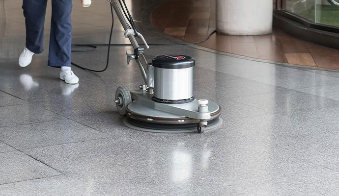 A professional operating a commercial floor polishing machine.