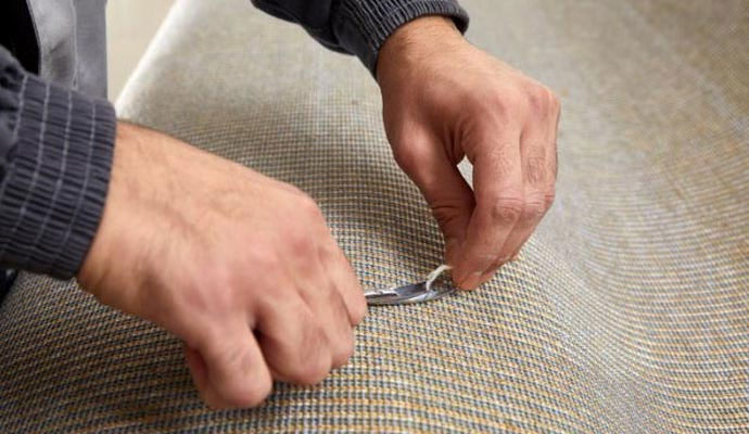 Professional using scissors to cut upholstery fabric
